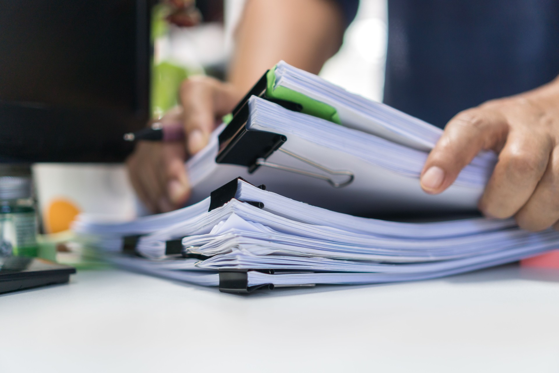 Paperwork files searching information business concept, Businessman hands typing keyboard computer, working in stacks of report papers and piles of unfinished documents achieves on office desk